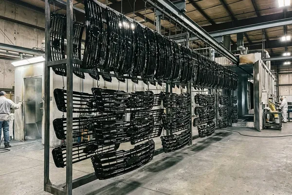 Powder-coated automotive grille parts in glossy black finish